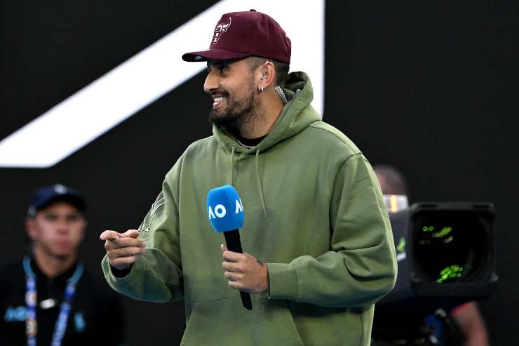 Kyrgios sorride con un microfono degli Australian Open in mano